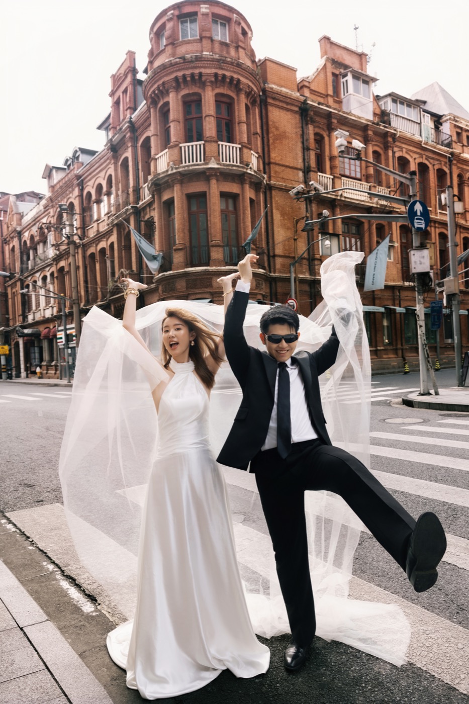 两人在城市街角举起婚纱的婚纱照